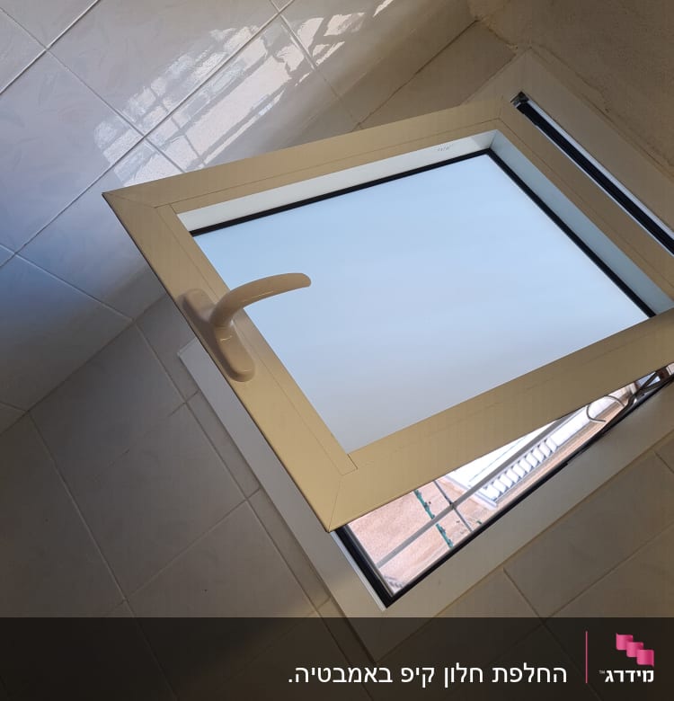 חלון אלומיניום פתוח עם ידית לבנה